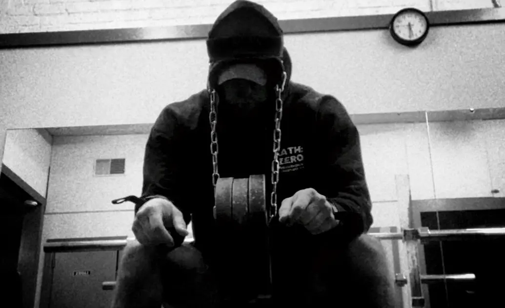 Man in hoodie with weights hanging around his neck